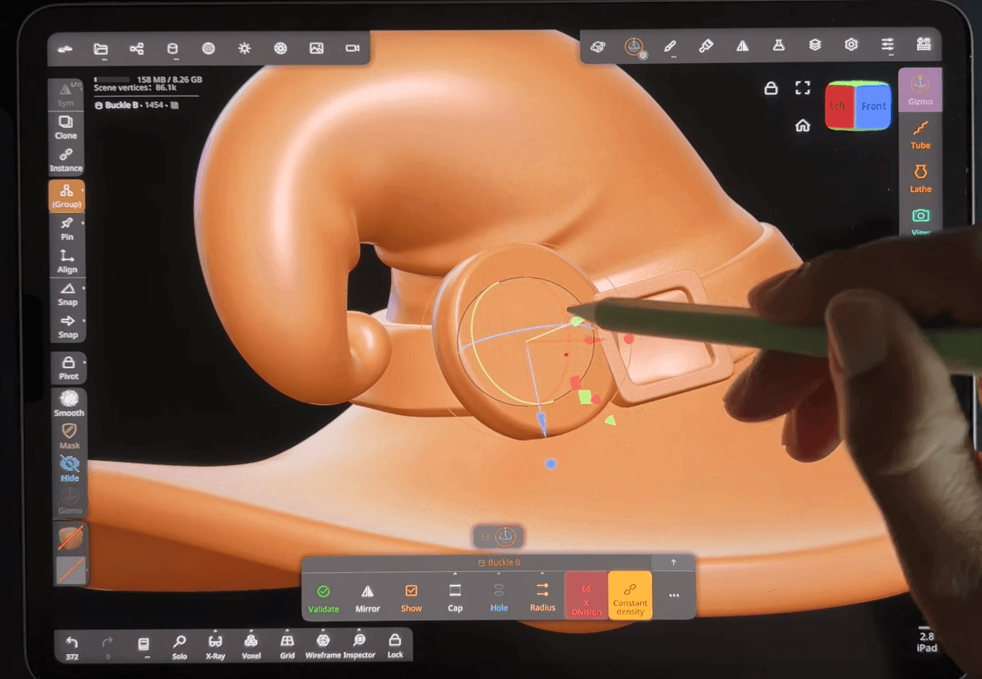 Nomad Sculpt on an iPad showing a stylus editing a 3D model with modeling tools and transformation controls.